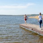 a man and a woman walking along a pier