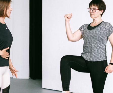 Two women working out together, demonstrating fitness exercises on a white background.
