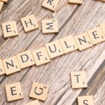 scrabble tiles spelling the word mindfulness on a wooden surface