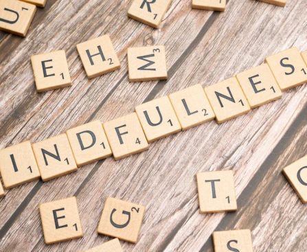 scrabble tiles spelling the word mindfulness on a wooden surface