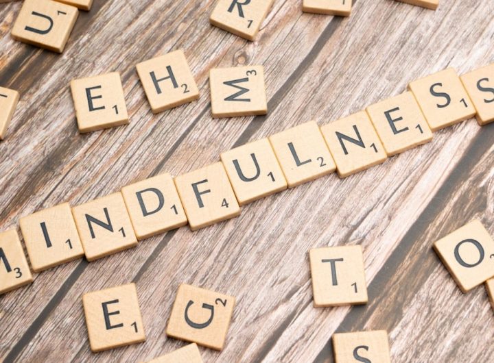 scrabble tiles spelling the word mindfulness on a wooden surface